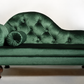 Green velvet chaise lounge with tufted backrest on a white background
