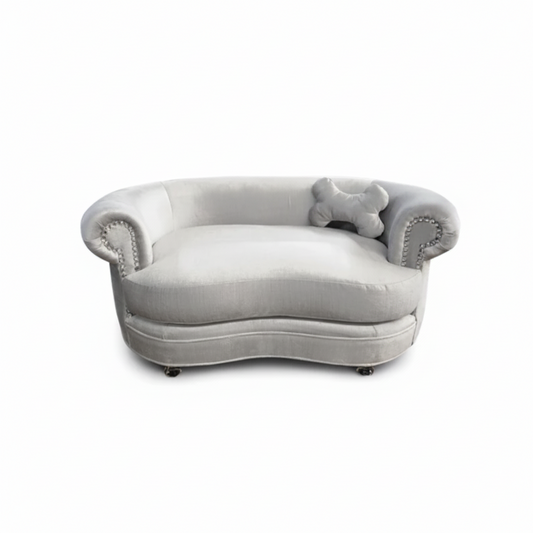 Gray plush dog bed with decorative armrests on a white background