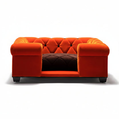 Orange tufted sofa with a brown quilted cushion on a white background